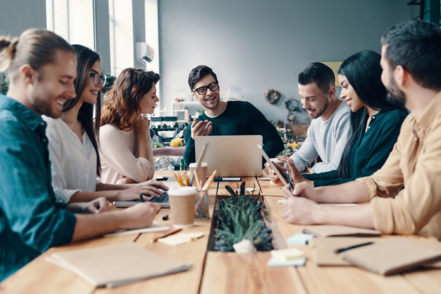 A team collaborating around a laptop in a modern office